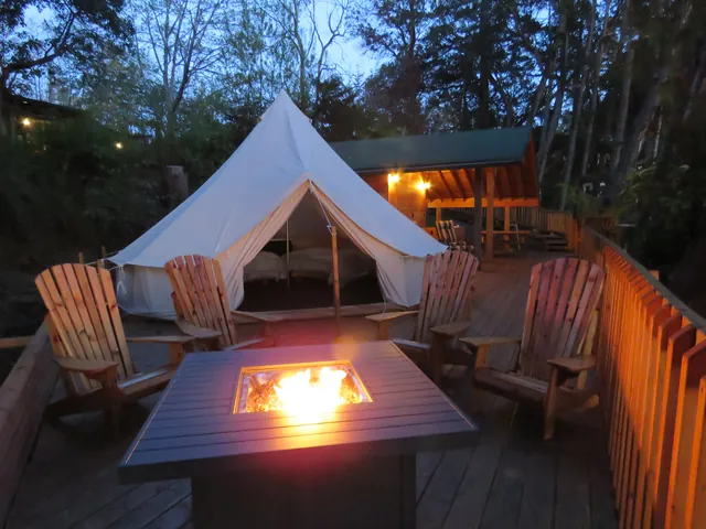Glamping Pad – Propane fire table lit at dusk beside the bell tent