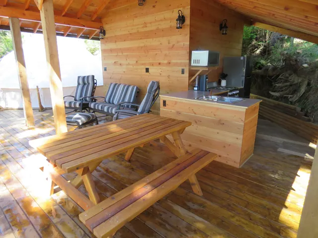 Glamping Pad – Covered lounge, picnic table, and kitchen island